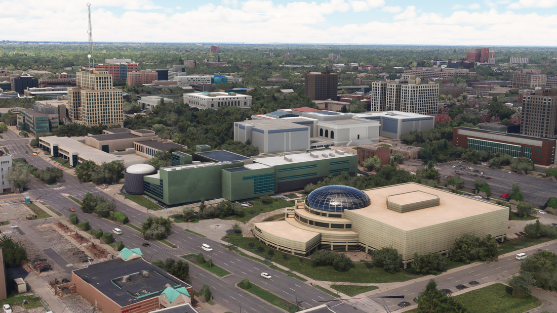 Daylight aerial view of Midtown Detroit cultural buildings, tree-lined streets, and varied roof shapes