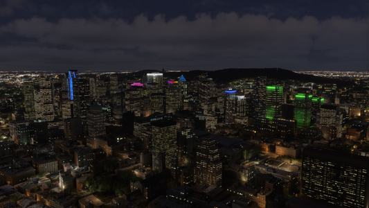 Montreal downtown towers illuminated at night with blue, pink and green lighting accents