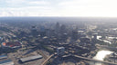 Daytime aerial view of Cleveland, Ohio MSFS scenery, with downtown towers, the football stadium, and a river bridge.