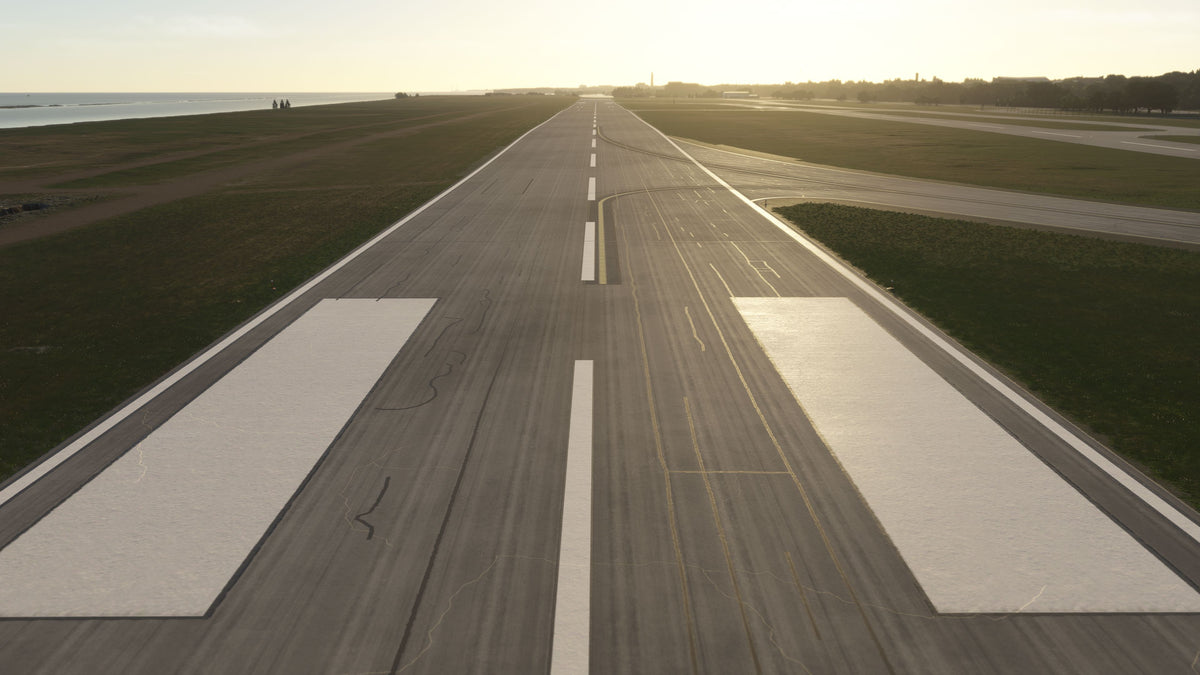 View along the KBKL runway centerline and aiming-point markings in golden-hour light, with Lake Erie alongside in MSFS.