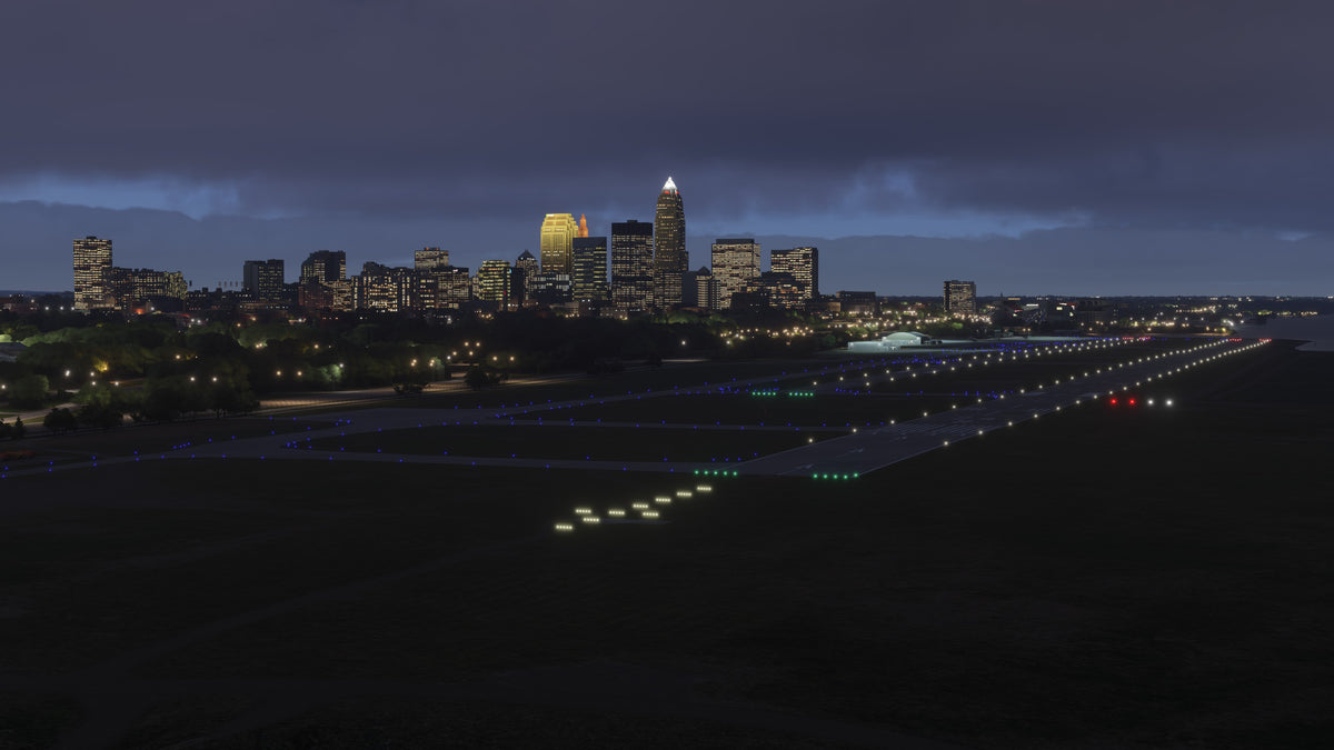 Illuminated runways and blue taxiway lights at KBKL Burke Lakefront Airport, with Cleveland's skyline at night in MSFS.