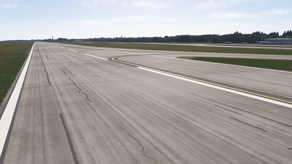 Daylight view along a KBKL runway with worn pavement, white centerline markings and a curved taxiway exit in MSFS.