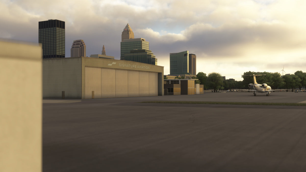 Signature Aviation hangar at KBKL with a parked business jet and Cleveland skyline in golden-hour light in MSFS.