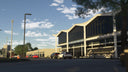 Burke Lakefront Airport terminal entrance with airport signage, tall windows and parked cars in daylight in MSFS.