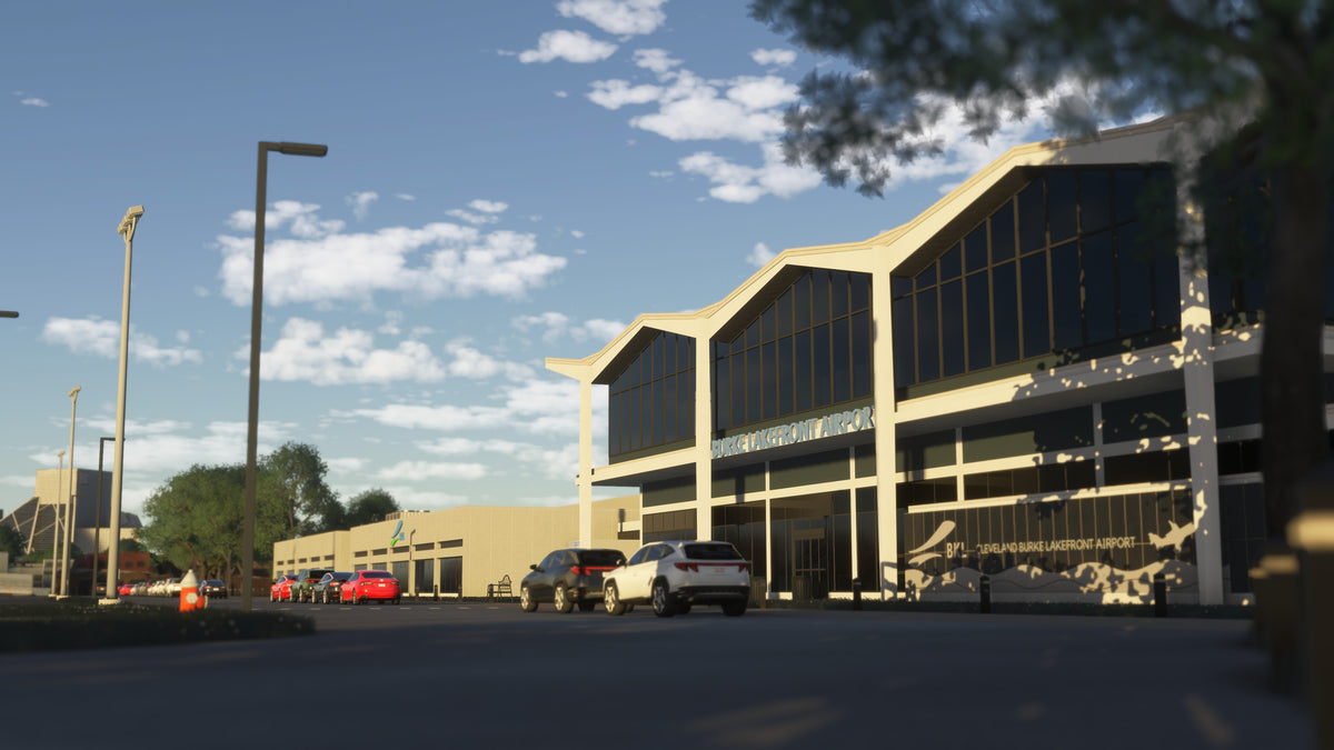 Burke Lakefront Airport terminal entrance with airport signage, tall windows and parked cars in daylight in MSFS.