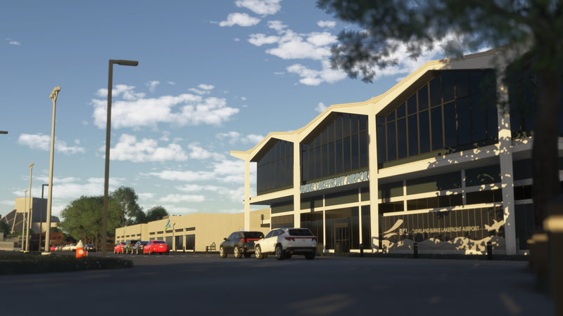 Burke Lakefront Airport terminal entrance with airport signage, tall windows and parked cars in daylight in MSFS.