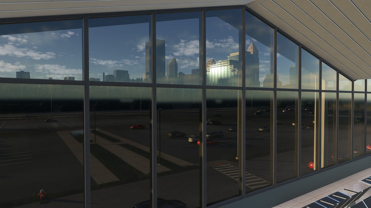 View through KBKL terminal windows toward the parking area and Cleveland skyline in golden-hour light in MSFS.